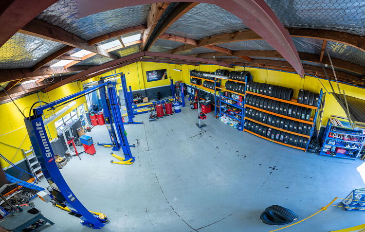 Wide view of the Hamilton Auto Centre workshop with tyre racks and vehicle hoists