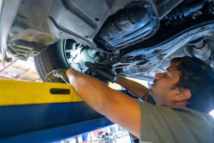 Hamilton Auto Centre mechanic inspecting underside of a car on a hoist